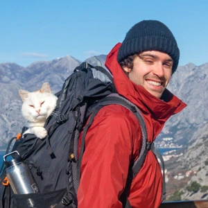 Scott with a cat in his rucksack